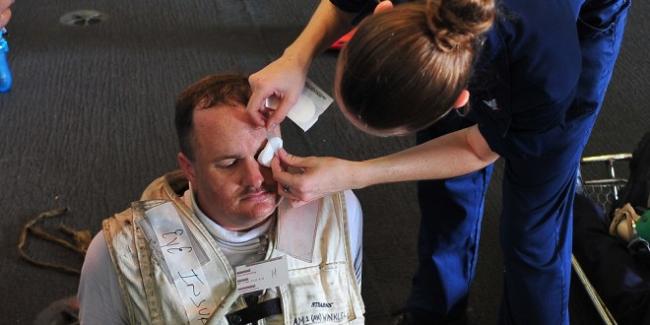 US_Navy_100815-N-0593C-007_Aviation_Structural_Mechanic_1st_Class_Paul_G._Winkler_is_treated_for_a_simulated_eye_injury_during_a_mass_casualty_exercise_aboard_USS_Enterprise_CVN_65-660x330